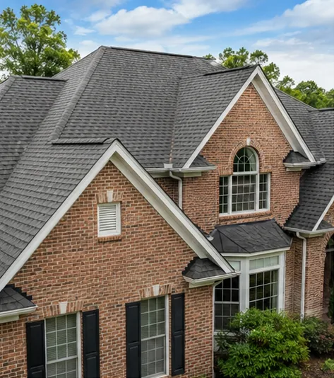 A completed architectural shingle roof on a brick home